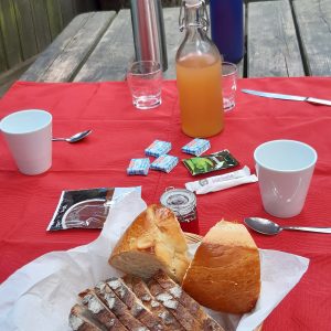 Hébergement insolite en Auvergne-Rhône-Alpes, table en bois avec petit-déjeuner gourmand.