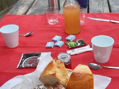 Hébergement insolite en Auvergne-Rhône-Alpes, table en bois avec petit-déjeuner gourmand.