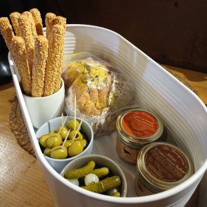Hébergement insolite en Centre : panier gourmand avec olives, cornichons et biscuits.
