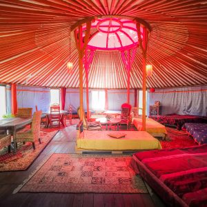 Yourte colorée en Basse-Normandie, avec un intérieur chaleureux et des tapis moelleux.