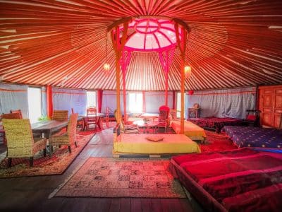 Yourte colorée en Basse-Normandie, avec un intérieur chaleureux et des tapis moelleux.
