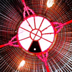 Hébergement insolite en yourte, vue intérieure avec un plafond coloré et lumineux.