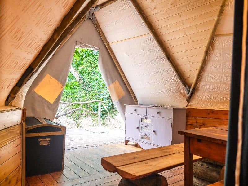Tente lodge spacieuse avec cuisine, offrant une vue sur la nature verdoyante.
