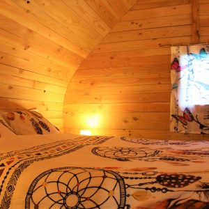 Chalet en bois chaleureux avec lit douillet et décor coloré à Languedoc-Roussillon.