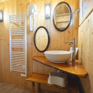 Salle de bain en bois dans un hébergement insolite en Pays de la Loire. Éléments modernes.