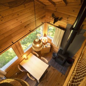 Cabane en bois dans les Pays de la Loire, avec vue sur la nature et un poêle à bois.