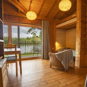 Cabane en bois avec vue sur le lac, ambiance chaleureuse et lumineuse.