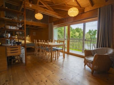Cabane en bois avec vue sur la nature, lumineuse et chaleureuse, idéale pour un séjour.