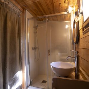 Salle de bain en bois dans un hébergement insolite en Pays de la Loire. Douche moderne.