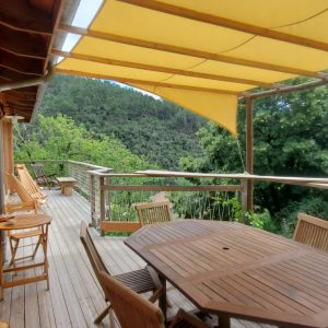 Hébergement insolite en Languedoc-Roussillon avec terrasse en bois et vue verdoyante.