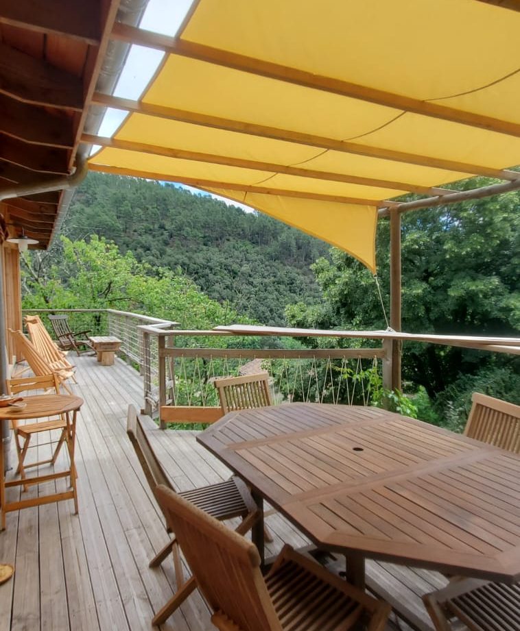Hébergement insolite en Languedoc-Roussillon avec terrasse en bois et vue verdoyante.