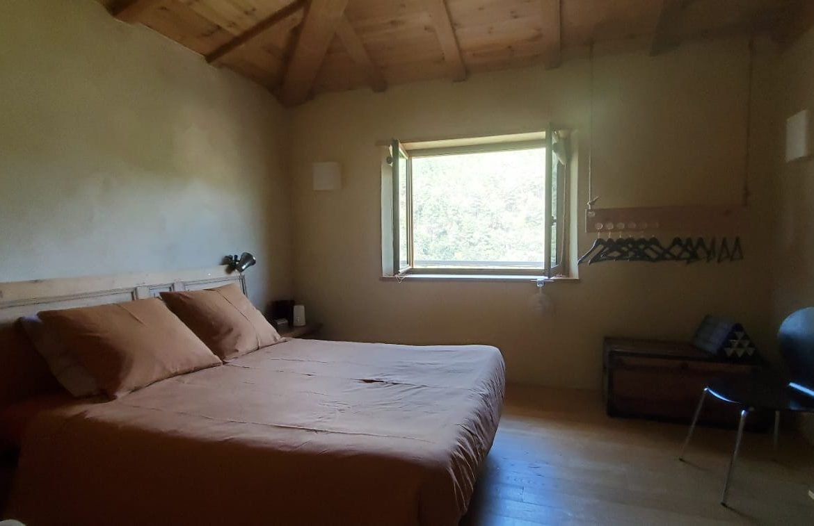 Chambre en bois dans un hébergement insolite, baignée de lumière naturelle.