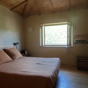 Chambre en bois dans un hébergement insolite, baignée de lumière naturelle.