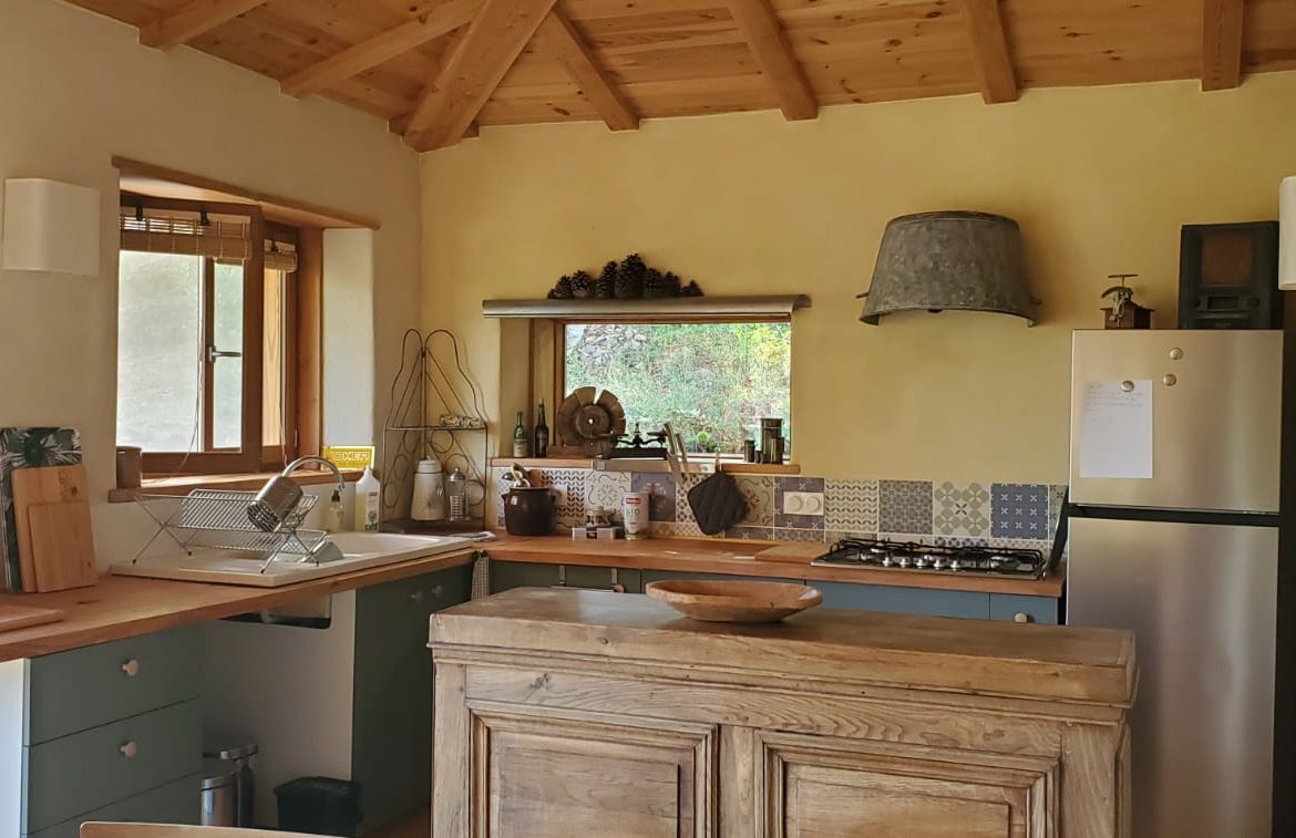 Hébergement insolite en Languedoc-Roussillon, cuisine chaleureuse avec plafond en bois.