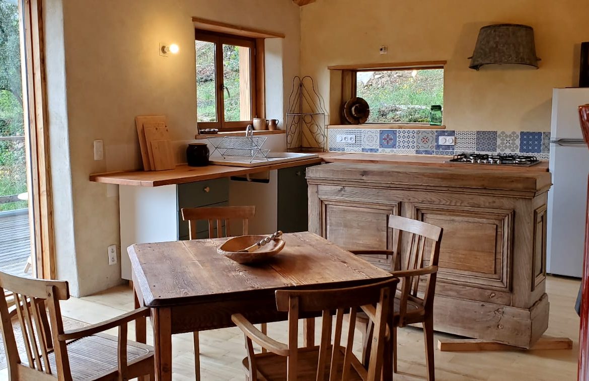 Hébergement insolite en Languedoc-Roussillon, cuisine chaleureuse avec mobilier en bois.