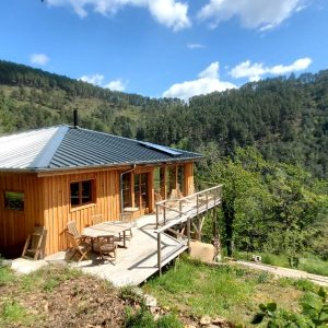 Chalet en bois avec terrasse, niché dans la verdure du Languedoc-Roussillon.