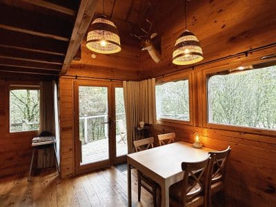 Cabane en bois à Pays de la Loire, avec un intérieur chaleureux et des lampes suspendues.