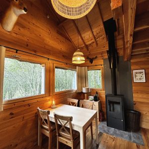 Cabane en bois à Pays de la Loire, avec un intérieur chaleureux et des fenêtres lumineuses.