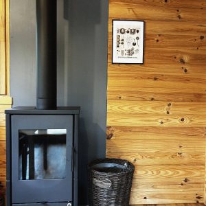Hébergement insolite en Pays de la Loire avec poêle à bois et murs en bois chaleureux.