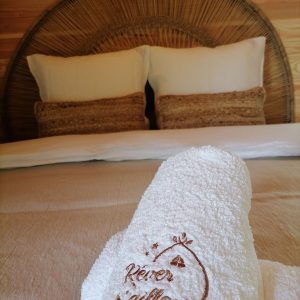 Chambre cocooning en bois avec linge de lit doux et décor naturel apaisant.