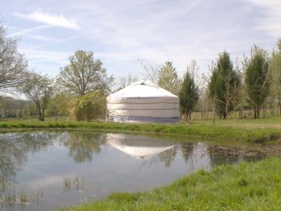 Yourte au bord dun étang, entourée de verdure dans le Pays de la Loire.