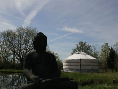 Yourte paisible au Pays de la Loire, avec une statue de Bouddha en arrière-plan.