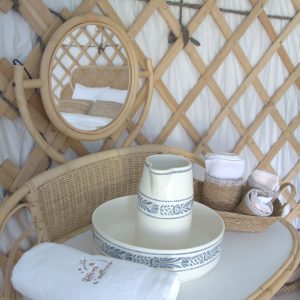 Hébergement insolite : yourte avec décor en bambou et miroir rond élégant.