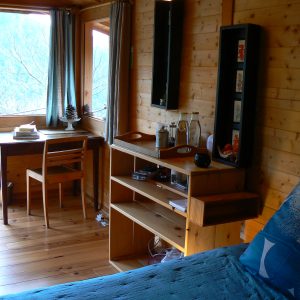 Chalet en bois lumineux avec vue sur la nature, ambiance chaleureuse et cosy.