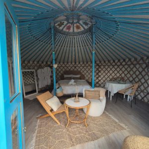 Yourte colorée avec un intérieur cosy et décoré, située en Pays de la Loire.