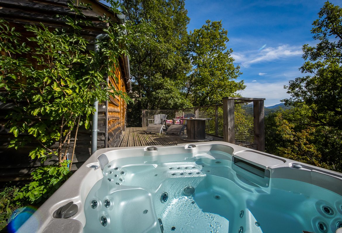 Hébergement insolite en bois avec jacuzzi, offrant une vue imprenable sur la nature.