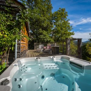 Hébergement insolite en bois avec jacuzzi, offrant une vue imprenable sur la nature.
