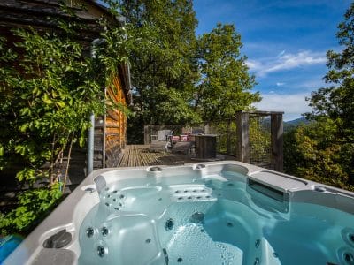 Hébergement insolite en bois avec jacuzzi, offrant une vue imprenable sur la nature.