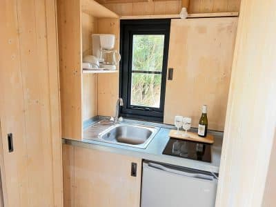 Cuisine moderne en bois dun hébergement insolite en Auvergne-Rhône-Alpes.