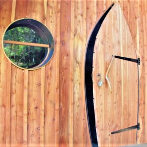 Cabane en bois avec une porte originale et des fenêtres rondes, au cœur du Languedoc-Roussillon.