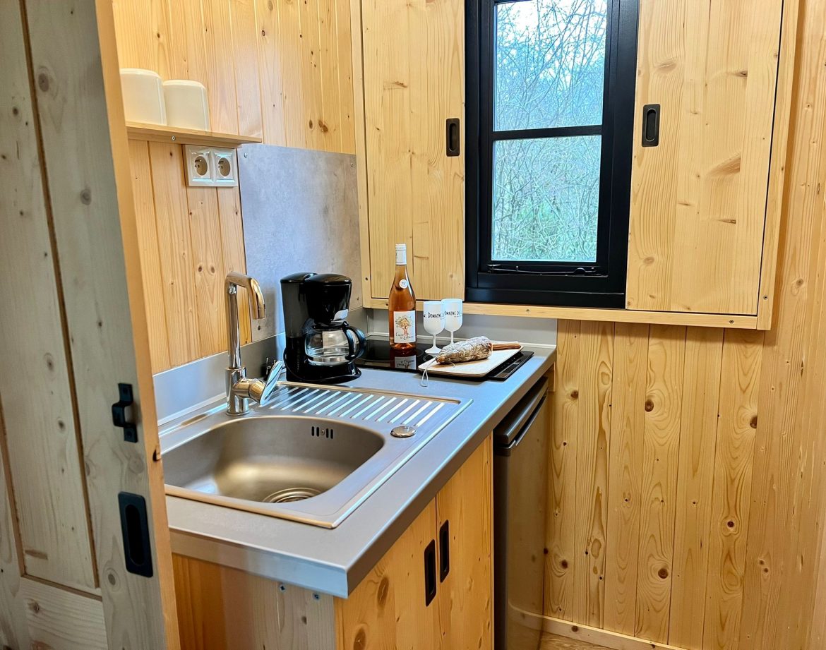 Cocooning en cabane en bois, cuisine équipée avec vue sur la nature.