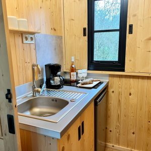 Cocooning en cabane en bois, cuisine équipée avec vue sur la nature.