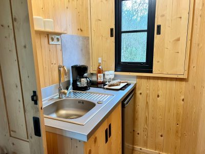 Cocooning en cabane en bois, cuisine équipée avec vue sur la nature.