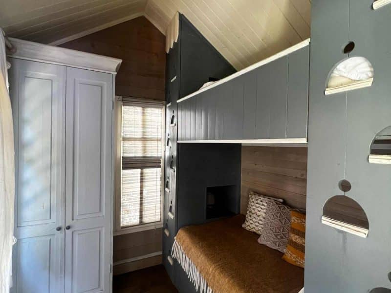 Chalet moderne avec lit douillet et décoration chaleureuse en bois.