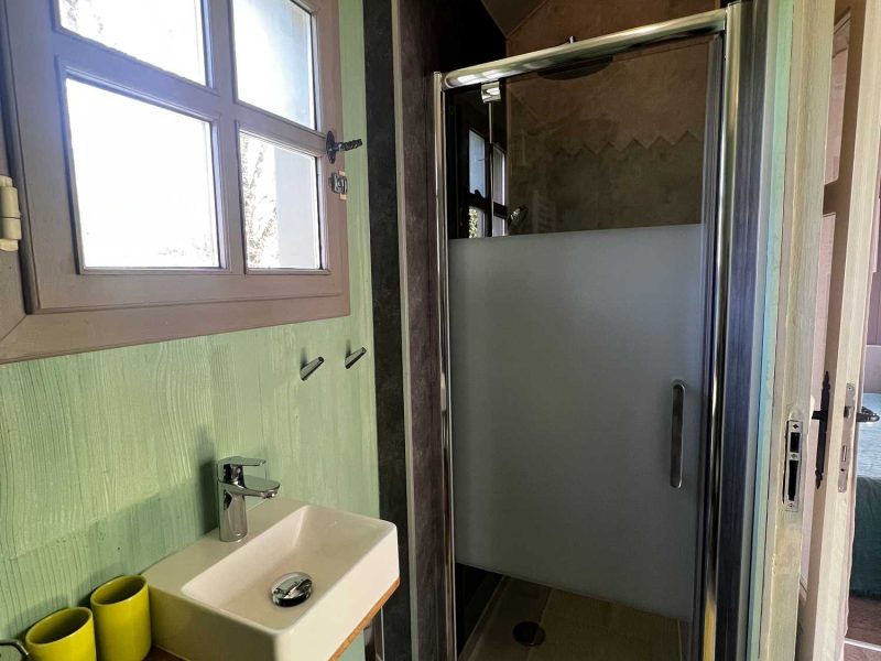 Salle de bain moderne dans un chalet, avec douche spacieuse et décor en bois.