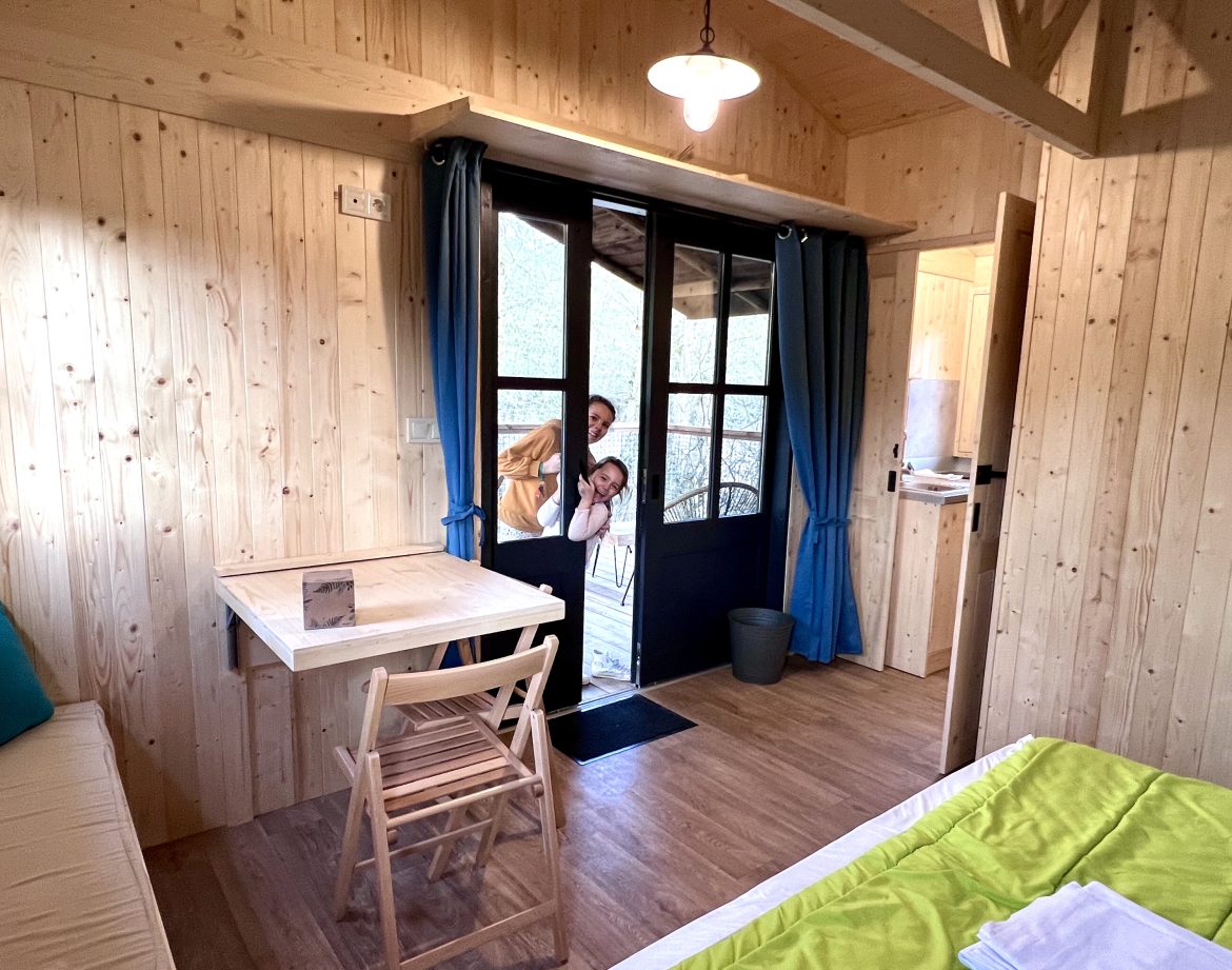 Cabane en bois chaleureuse avec vue sur la nature et intérieur lumineux.
