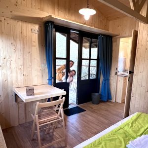 Cabane en bois chaleureuse avec vue sur la nature et intérieur lumineux.