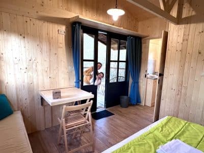 Cabane en bois chaleureuse avec vue sur la nature et intérieur lumineux.
