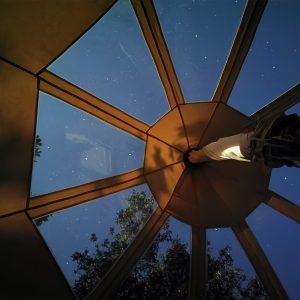 Tente suspendue à Languedoc-Roussillon, vue étoilée à travers le toit transparent.