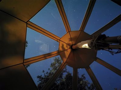 Tente suspendue à Languedoc-Roussillon, vue étoilée à travers le toit transparent.