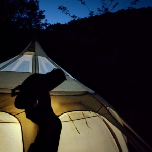 Tente suspendue dans le Languedoc-Roussillon, éclairée par une lampe à lintérieur.