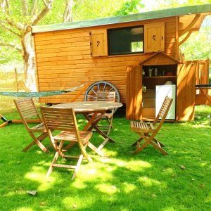 Cabane en bois dans le Languedoc-Roussillon, avec table en extérieur et hamac.