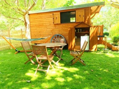 Cabane en bois dans le Languedoc-Roussillon, avec table en extérieur et hamac.