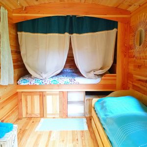 Hébergement insolite en bois avec lits douillets et décor naturel apaisant.