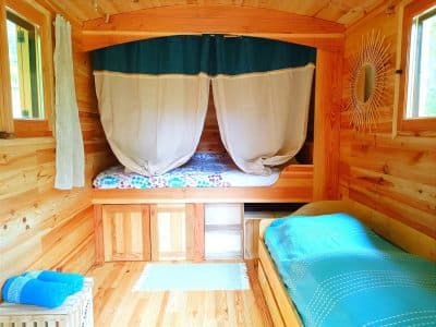 Hébergement insolite en bois avec lits douillets et décor naturel apaisant.