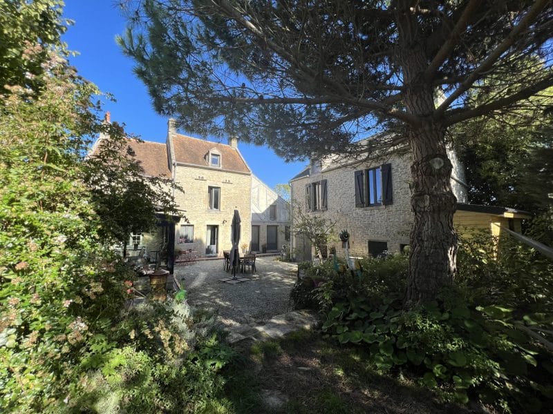 Charmante maison de campagne avec jardin fleuri et terrasse ensoleillée.